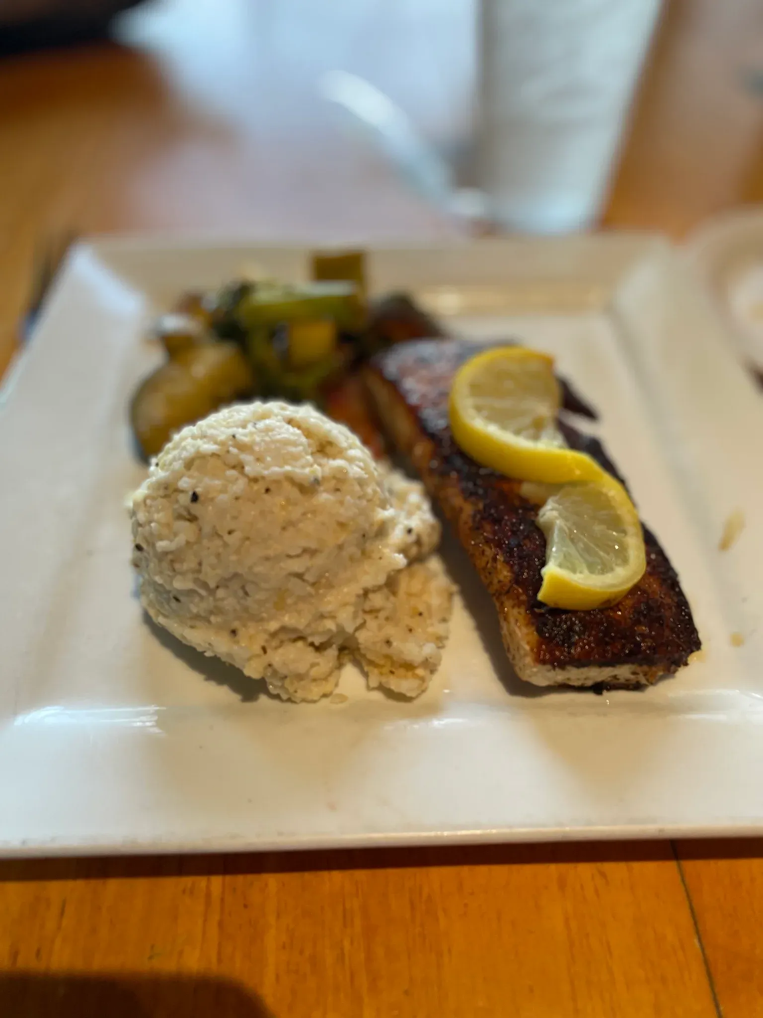 Blackened salmon with lemon, mashed potatoes, and roasted vegetables at The Docks
